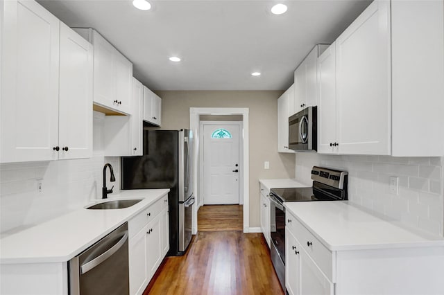 31 Tappan Ave, Babylon, NY 11702 - kitchen featuring stainless steel appliances, wood finished floors, recessed lighting, white cabinets, and tasteful backsplash