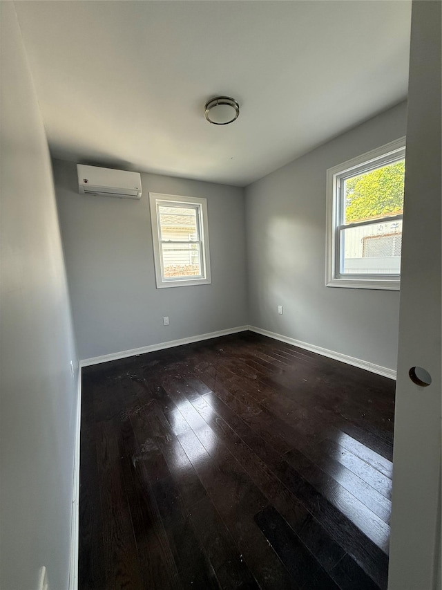 4006 Rockaway Beach Blvd, Edgemere, NY 11691 - spare room featuring an AC wall unit, dark wood-style flooring, and healthy amount of natural light