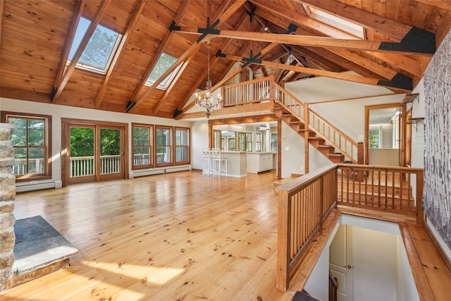 25 Cascade Lake Rd, Warwick, NY 10990 - unfurnished living room with a skylight, baseboard heating, hardwood / wood-style flooring, high vaulted ceiling, and stairs