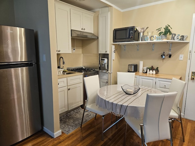 76-26 113th St Unit 2D, Forest Hills, NY 11375 - kitchen featuring freestanding refrigerator, under cabinet range hood, dark wood-style flooring, white cabinets, and light countertops