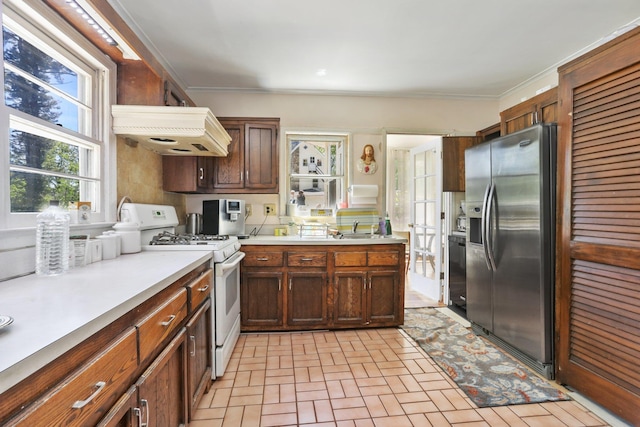 42 N Healy Ave, Hartsdale, NY 10530 - kitchen with stainless steel fridge, white range with gas cooktop, light countertops, custom range hood, and brick patterned floors