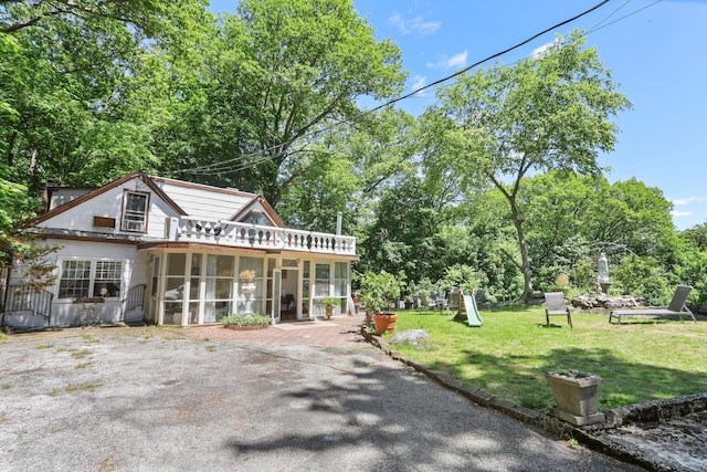 42 N Healy Ave, Hartsdale, NY 10530 - back of property featuring a sunroom, a yard, and view of scattered trees