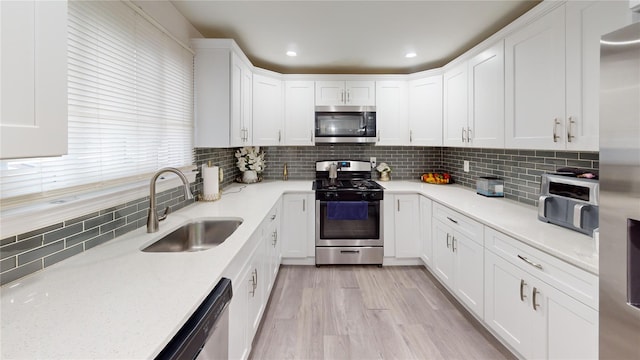 10 Marilyn Ct, West Babylon, NY 11704 - kitchen featuring stainless steel appliances, white cabinetry, tasteful backsplash, recessed lighting, and light wood finished floors