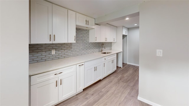 10 Marilyn Ct, West Babylon, NY 11704 - kitchen with backsplash, light countertops, white cabinetry, light wood-type flooring, and recessed lighting