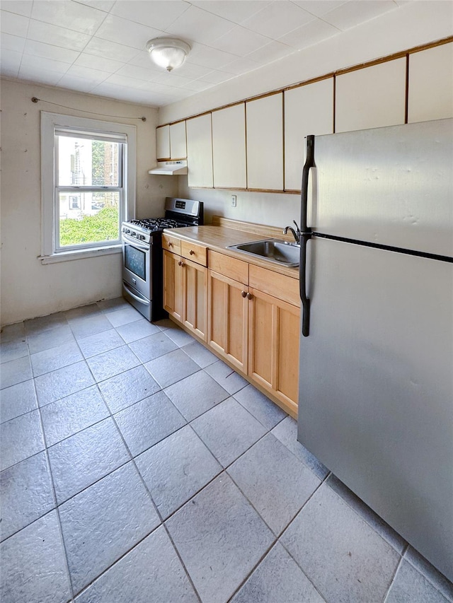 19-23 23rd Rd, Astoria, NY 11105 - kitchen with stainless steel appliances, under cabinet range hood, light countertops, and light tile patterned flooring