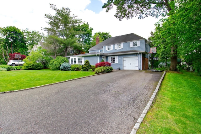 20 Primrose Ln, East Hills, NY 11577 - view of front of house featuring a garage, driveway, a chimney, and a front lawn