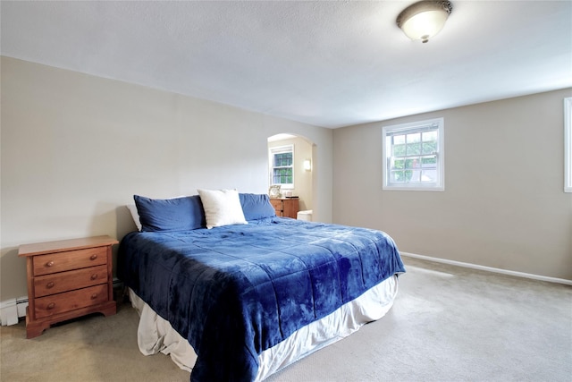 20 Primrose Ln, East Hills, NY 11577 - bedroom with arched walkways, light colored carpet, and a baseboard heating unit