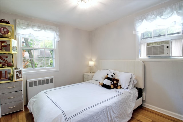 20 Primrose Ln, East Hills, NY 11577 - bedroom featuring radiator, wood finished floors, and cooling unit