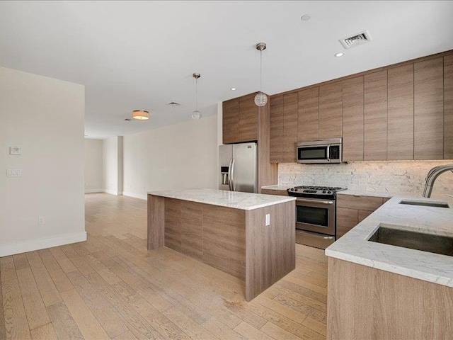 160 Bch 5th St, Far Rockaway, NY 11691 - kitchen with stainless steel appliances, a kitchen island, tasteful backsplash, light wood-style floors, and pendant lighting