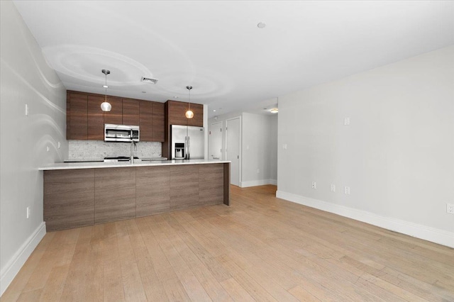 160 Bch 5th St, Far Rockaway, NY 11691 - kitchen featuring appliances with stainless steel finishes, modern cabinets, light wood-type flooring, and backsplash