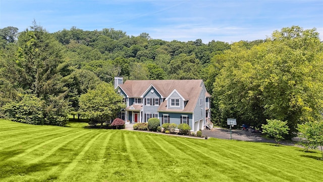 64 Lambert Rdg, Cross River, NY 10518 - view of front of house featuring a front yard, a wooded view, and asphalt driveway