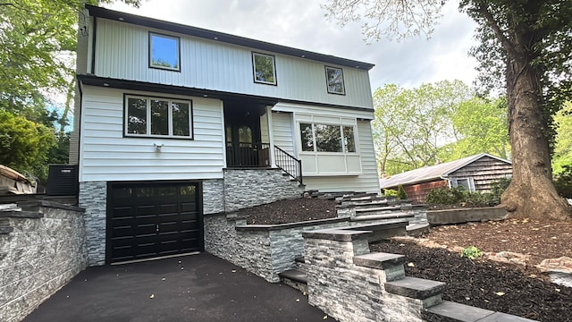 45 Forest Dr, Centerport, NY 11721 - view of front facade featuring driveway, an attached garage, and stone siding