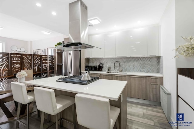 2222 Ocean Ave Ph-B, Ph-B Brooklyn, NY 11229 - kitchen featuring island range hood, modern cabinets, appliances with stainless steel finishes, a kitchen breakfast bar, and decorative backsplash