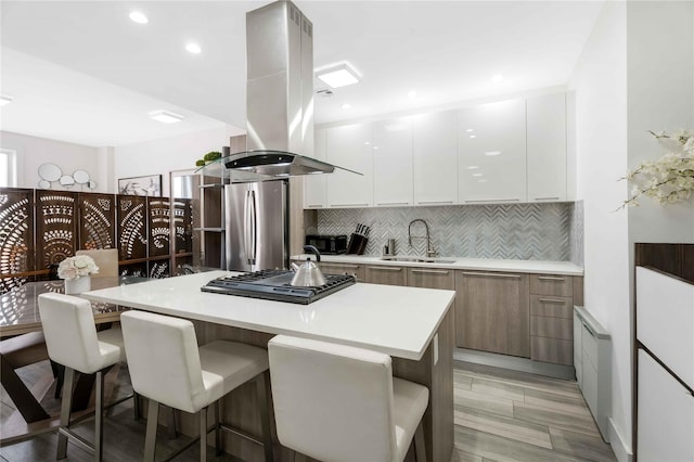 2222 Ocean Ave Ph-B, Ph-B Brooklyn, NY 11229 - kitchen with island range hood, modern cabinets, stainless steel appliances, a kitchen breakfast bar, and decorative backsplash