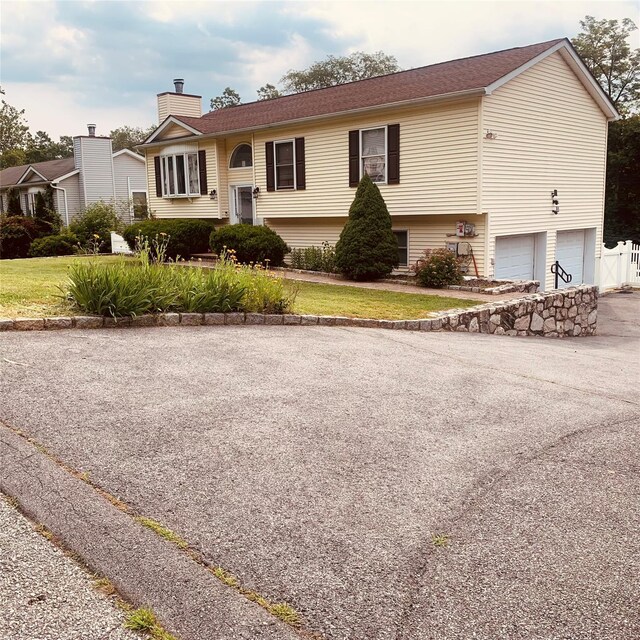 5 Sabrina Ln, Ossining, NY 10562 - bi-level home featuring a chimney, a garage, and asphalt driveway