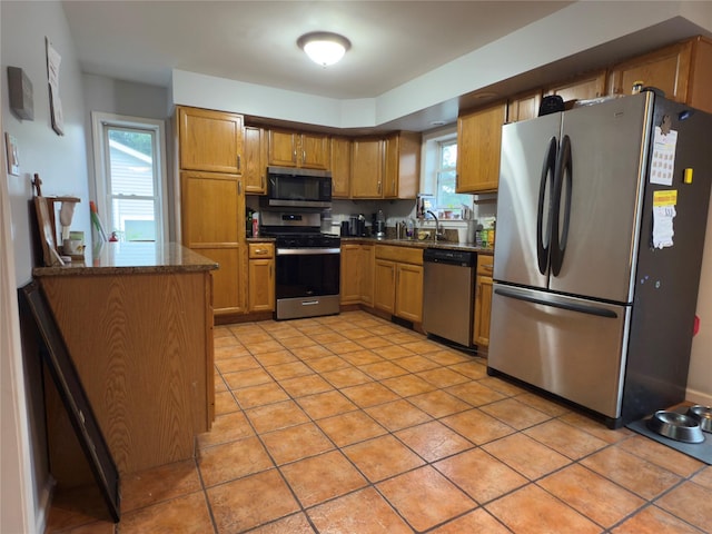 5 Sabrina Ln, Ossining, NY 10562 - kitchen featuring appliances with stainless steel finishes, light tile patterned flooring, and brown cabinetry