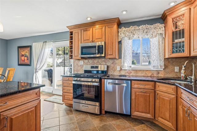 3706 Regent Ln, Wantagh, NY 11793 - kitchen with appliances with stainless steel finishes, dark stone countertops, brown cabinetry, backsplash, and recessed lighting