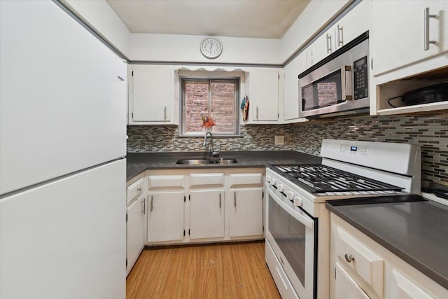 710 E 213th St, Bronx, NY 10467 - kitchen featuring white appliances, dark countertops, backsplash, light wood finished floors, and white cabinetry