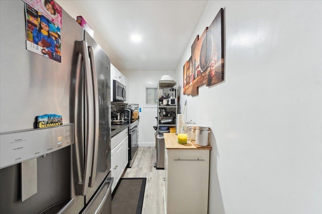 710 E 213th St, Bronx, NY 10467 - kitchen with appliances with stainless steel finishes, light wood-style floors, and white cabinets