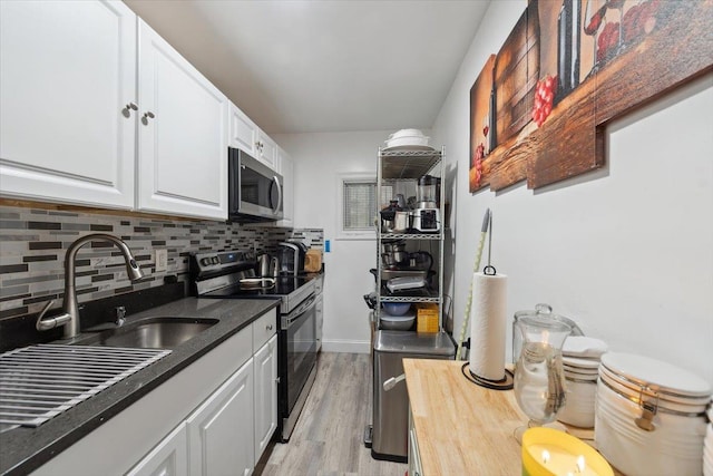 710 E 213th St, Bronx, NY 10467 - kitchen featuring appliances with stainless steel finishes, white cabinets, decorative backsplash, light wood-style flooring, and wooden counters