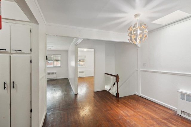 710 E 213th St, Bronx, NY 10467 - hallway with radiator heating unit, an upstairs landing, wood finished floors, and crown molding