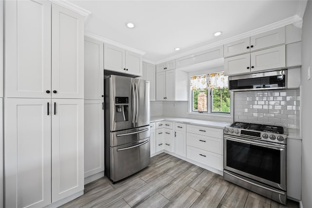 11 Trescott St, Dix Hills, NY 11746 - kitchen with appliances with stainless steel finishes, light countertops, tasteful backsplash, white cabinetry, and light wood-style floors