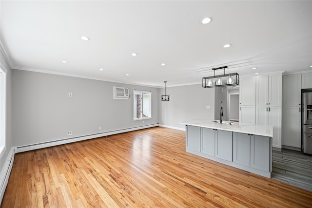 11 Trescott St, Dix Hills, NY 11746 - unfurnished living room with a baseboard heating unit, crown molding, light wood-style floors, recessed lighting, and an AC wall unit
