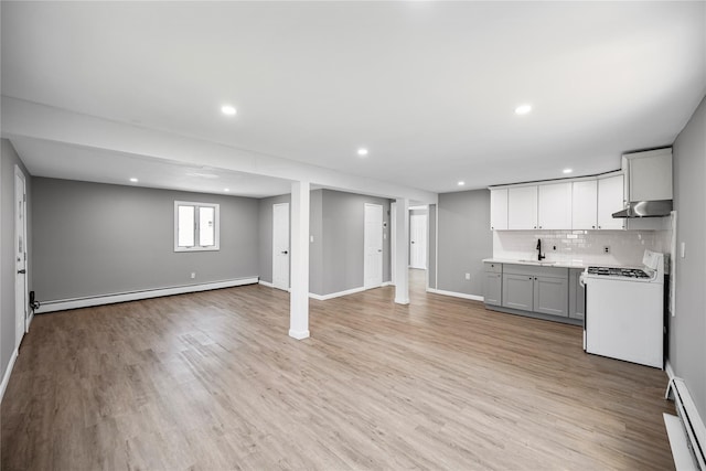 11 Trescott St, Dix Hills, NY 11746 - kitchen featuring white gas stove, under cabinet range hood, a baseboard heating unit, open floor plan, and recessed lighting