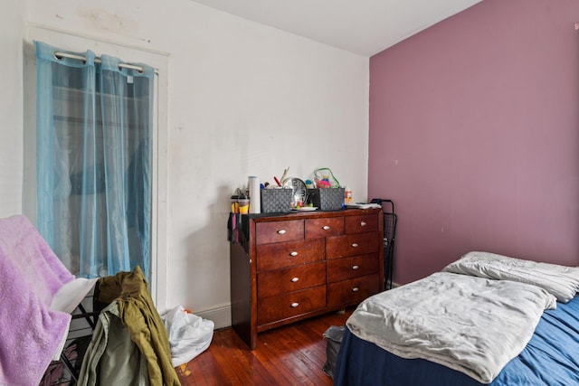 9406 76th St, Ozone Park, NY 11416 - bedroom with dark wood-style flooring and baseboards