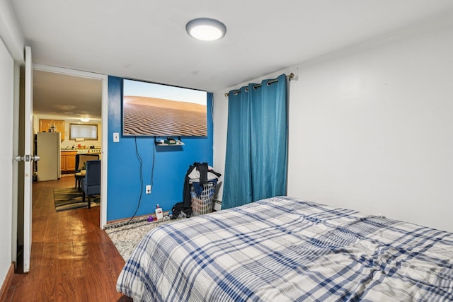 9406 76th St, Ozone Park, NY 11416 - bedroom featuring freestanding refrigerator and dark wood-style floors