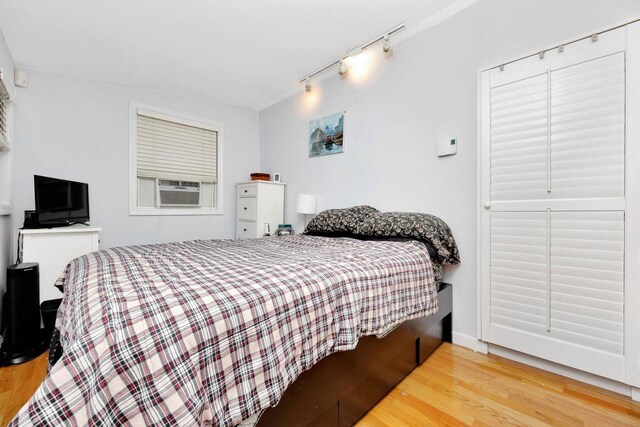 101 Alice St, Port Jefferson, NY 11777 - bedroom featuring track lighting, cooling unit, and wood finished floors