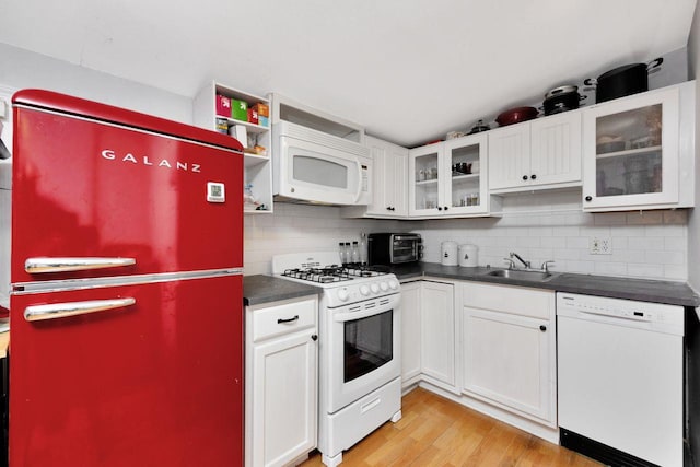 101 Alice St, Port Jefferson, NY 11777 - kitchen featuring white appliances, dark countertops, decorative backsplash, light wood-style flooring, and white cabinetry