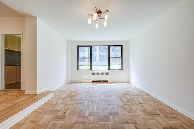 98-22 63rd Dr Unit 1D, Rego Park, NY 11374 - unfurnished room featuring radiator heating unit and a chandelier