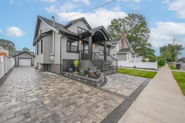 108 Bismark Ave, Valley Stream, NY 11581 - view of front facade with a detached garage, an outdoor structure, driveway, roof with shingles, and a porch