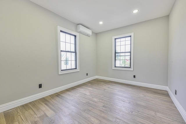 108 Bismark Ave, Valley Stream, NY 11581 - unfurnished room with a wall unit AC, light wood-style floors, and recessed lighting