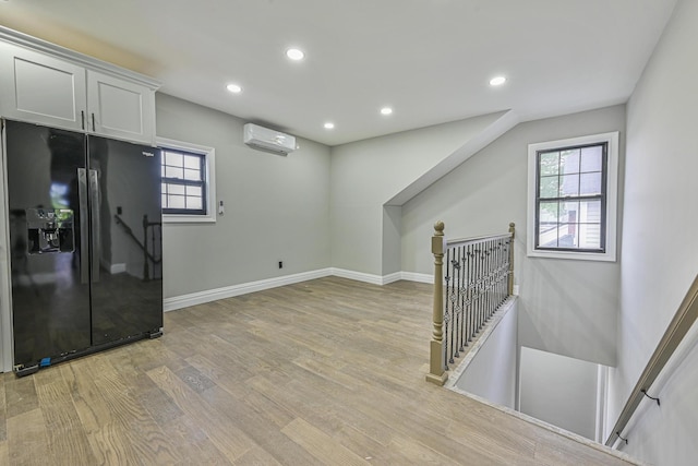 108 Bismark Ave, Valley Stream, NY 11581 - kitchen featuring black fridge with ice dispenser, a wall unit AC, light wood finished floors, recessed lighting, and healthy amount of natural light