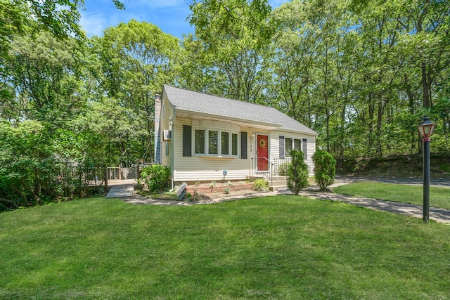 107 Cedar Ln, Medford, NY 11763 - view of front of property featuring a front yard, a chimney, and a shingled roof