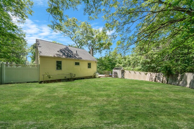 107 Cedar Ln, Medford, NY 11763 - rear view of house with a fenced backyard, a chimney, and a storage shed