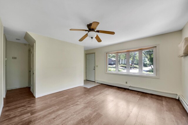 107 Cedar Ln, Medford, NY 11763 - unfurnished room featuring a baseboard heating unit, wood finished floors, and ceiling fan