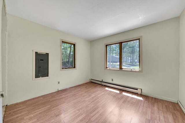 107 Cedar Ln, Medford, NY 11763 - unfurnished room featuring a baseboard heating unit, electric panel, and wood finished floors