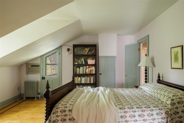 797 Western Rd, Call Listing Agent, NY 12033 - bedroom featuring radiator, a wall mounted AC, lofted ceiling, and wood finished floors