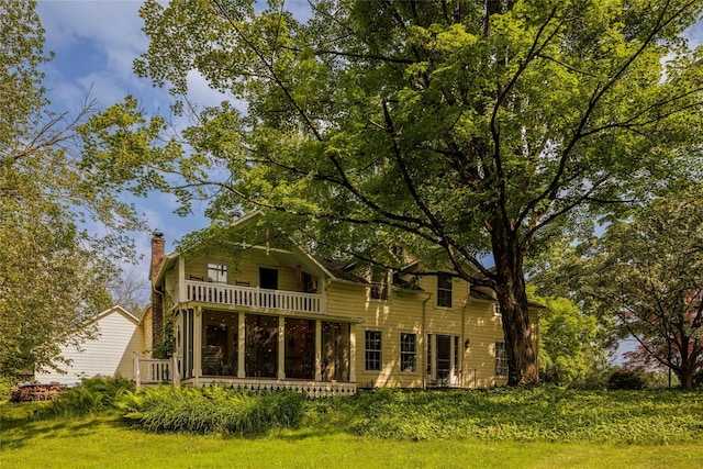 797 Western Rd, Call Listing Agent, NY 12033 - back of property featuring a chimney, a balcony, a sunroom, and a lawn