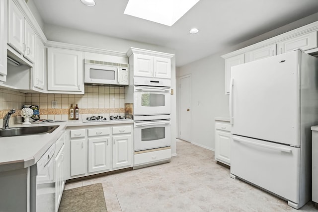 65 Shepherds Dr, Scarsdale, NY 10583 - kitchen featuring white appliances, backsplash, white cabinets, a skylight, and recessed lighting
