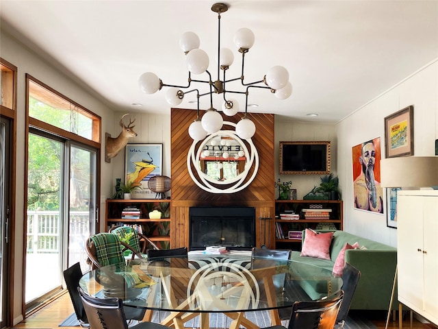 457 Fire Island Blvd, Fire Island Pines, NY 11782 - dining space featuring a chandelier, wood walls, wood finished floors, and a fireplace