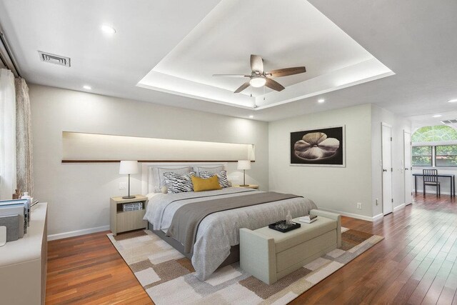 43 Hunt Dr, Jericho, NY 11753 - bedroom featuring wood finished floors, a tray ceiling, recessed lighting, and a ceiling fan
