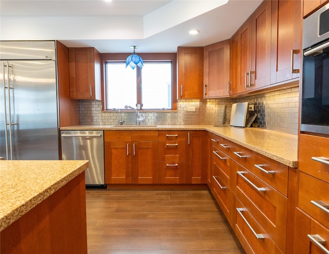 16107 90th St, Howard Beach, NY 11414 - kitchen featuring stainless steel appliances, brown cabinets, dark wood finished floors, recessed lighting, and light stone counters