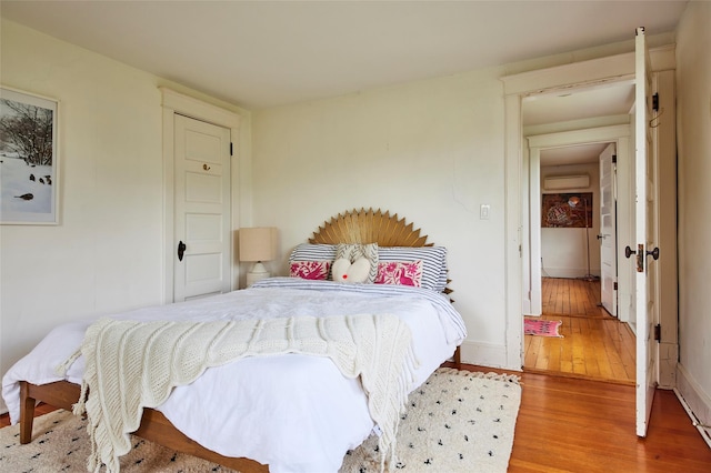 54 Davis Ln, Grahamsville, NY 12740 - bedroom featuring an AC wall unit and wood finished floors