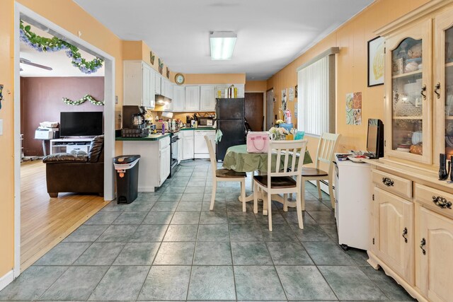 18 Happy Acres Dr, Shirley, NY 11967 - kitchen featuring freestanding refrigerator, glass insert cabinets, dark countertops, and extractor fan