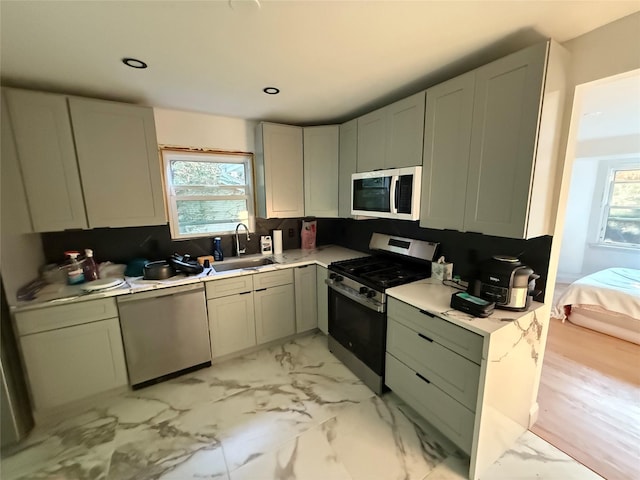 1 Whippoorwill Trl, Monroe, NY 10950 - kitchen featuring appliances with stainless steel finishes, light countertops, light marble finish floors, decorative backsplash, and recessed lighting