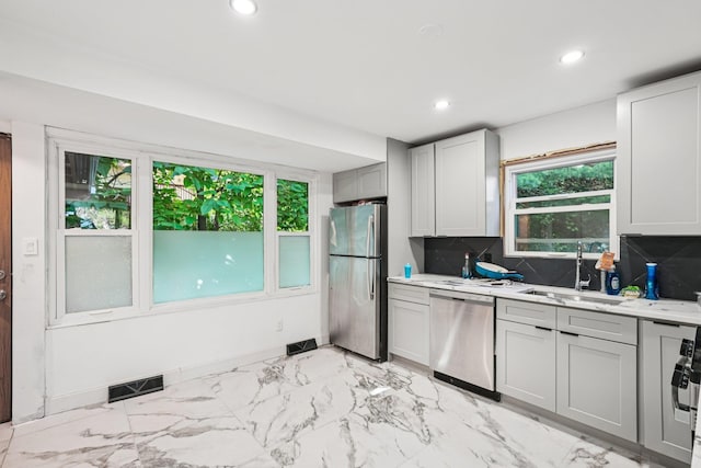 1 Whippoorwill Trl, Monroe, NY 10950 - kitchen with appliances with stainless steel finishes, recessed lighting, light marble finish flooring, backsplash, and gray cabinetry